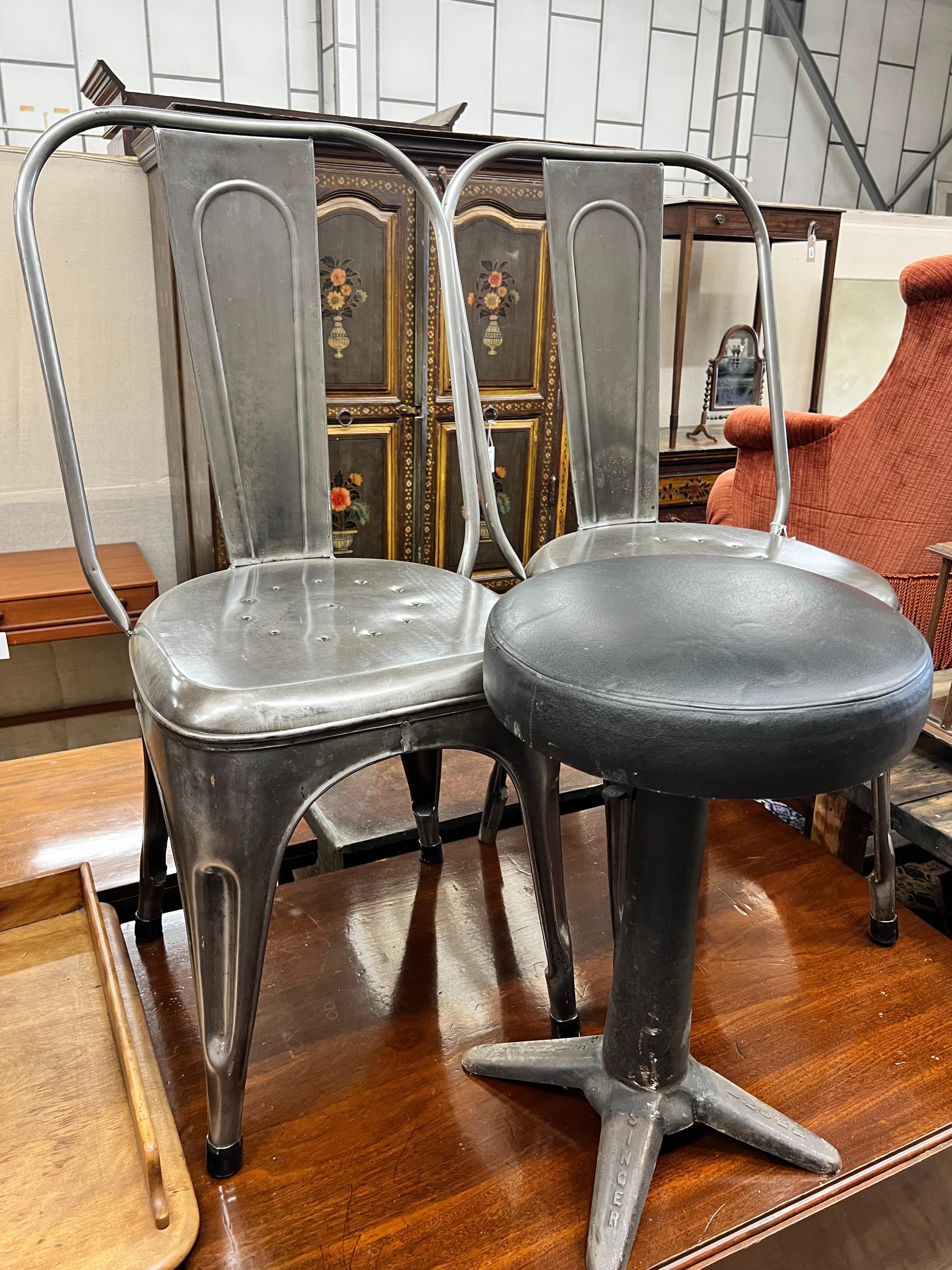 A pair of industrial style polished steel chairs and an adjustable Singer stool